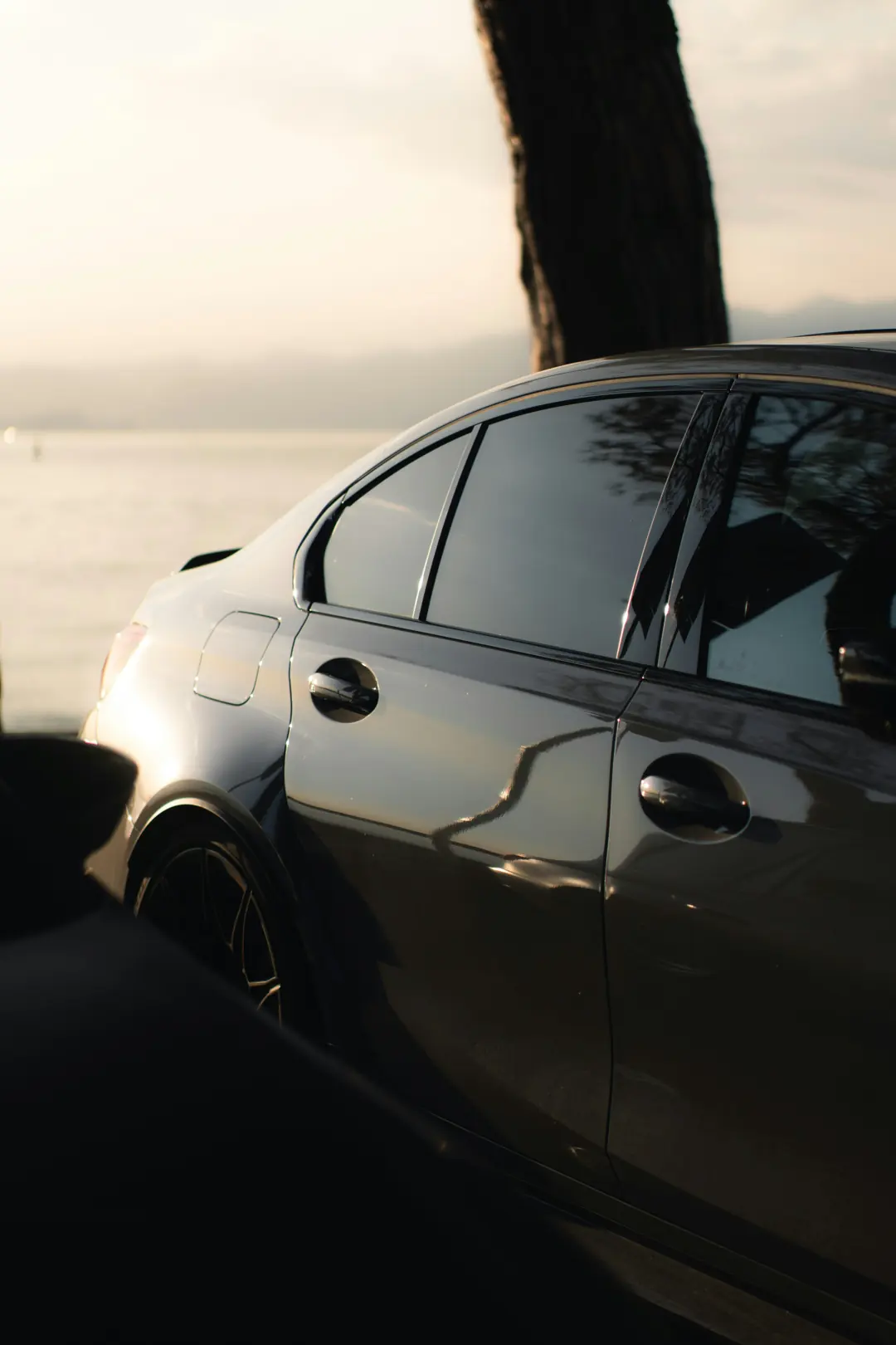 Dark ceramic tinted windows on a sedan at sunset