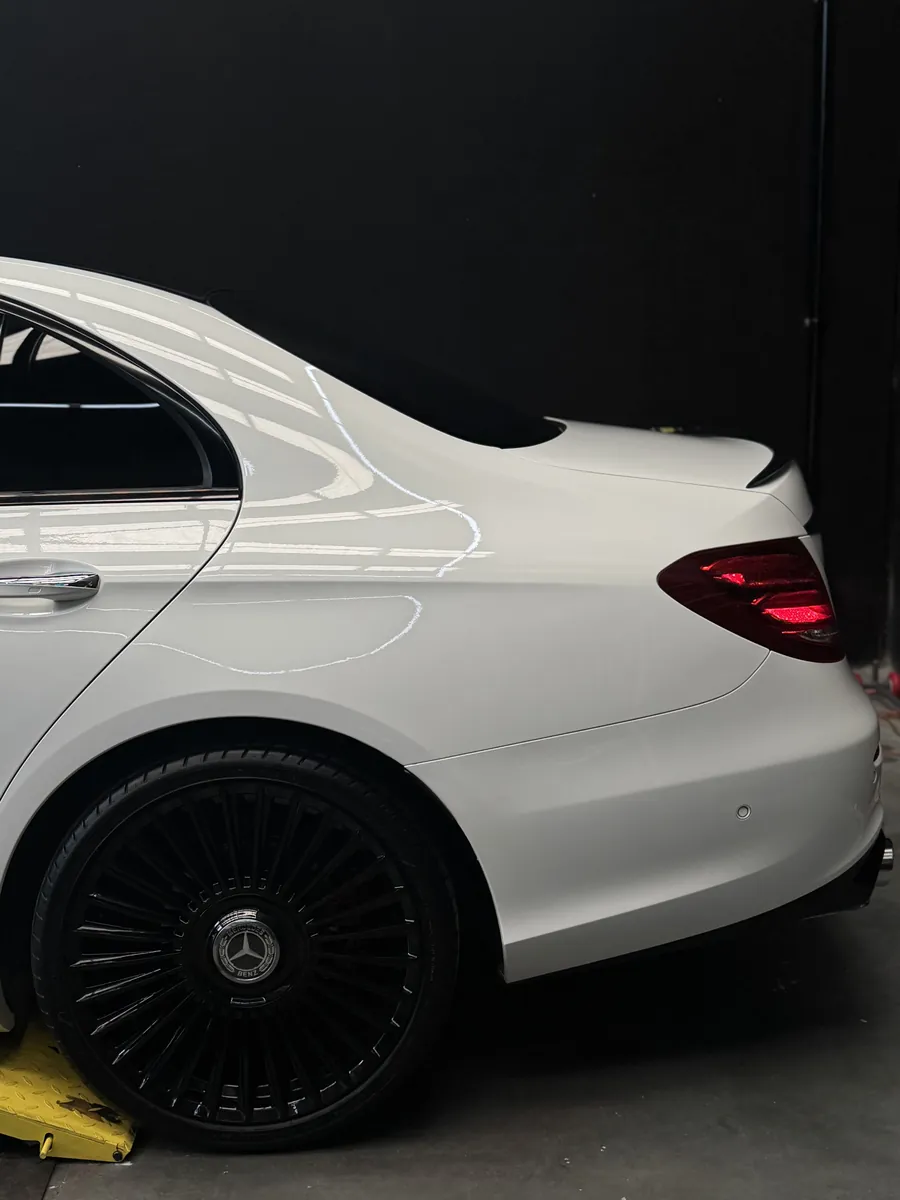 White Mercedes-Benz E-Class rear quarter with a mirror gloss finish